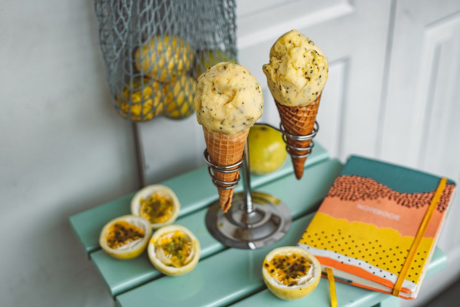 Imagem de uma sobremesa com dois sorvetes de creme em casquinha, acompanhada de limões sicilianos abertos e um caderno colorido ao lado, criando um ambiente descontraído e acolhedor.