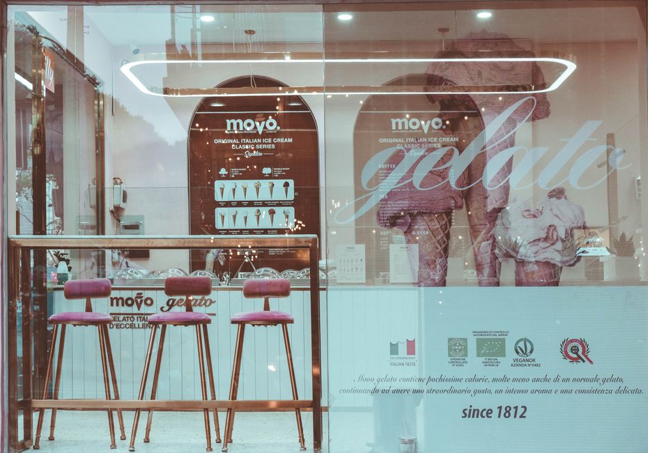 Vitrine de uma sorveteria artesanal destacando o tema de doces e sobremesas italianas, com móveis e decoração que remetem ao universo do gelato.