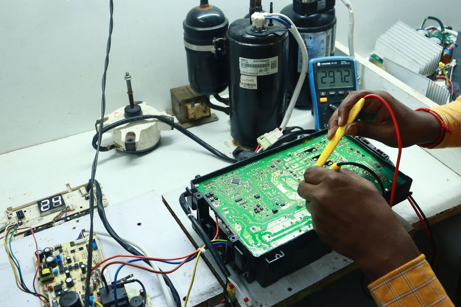 Técnico realizando manutenção em um circuito eletrônico em um laboratório de eletrônica ou tecnologia.