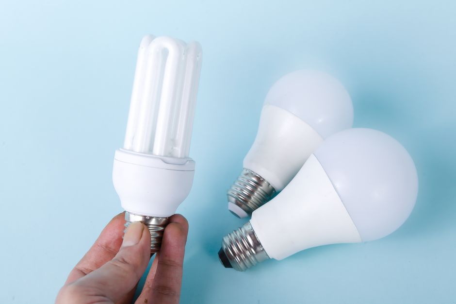 Imagem de três lâmpadas de LED modernas sendo exibidas sobre fundo azul claro, simbolizando inovação e economia de energia.