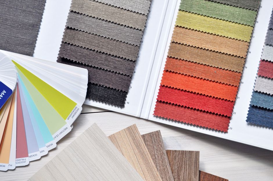 Mostruário de cores e texturas de materiais para design de interiores ou moda, exibido em um catálogo e amostras físicas.