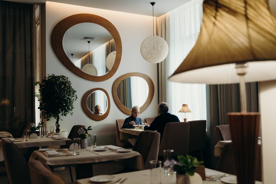 Imagem de um restaurante elegante com uma atmosfera acolhedora, iluminação suave e decoração moderna, ideal para artigos sobre experiências gastronômicas ou estética de espaços comerciais.