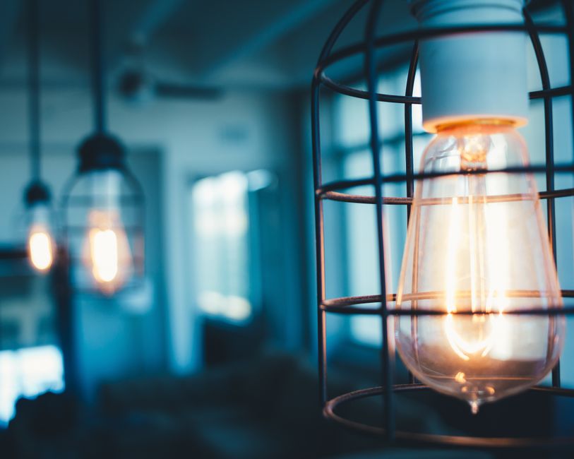Imagem de luminárias modernas com iluminação quente em um ambiente interno, transmitindo aconchego e estilo contemporâneo.