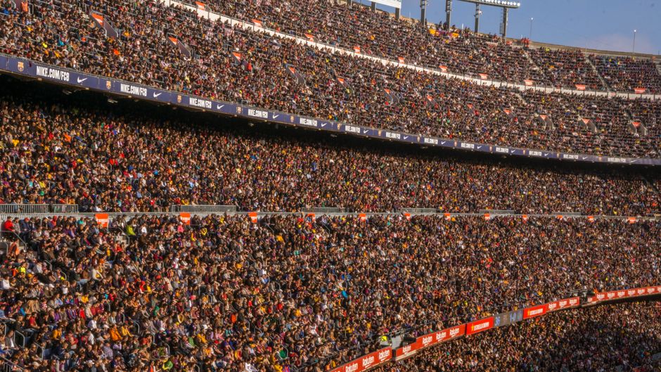 Imagem de um estádio lotado de torcedores, representando grande participação de público em eventos esportivos ou culturais.
