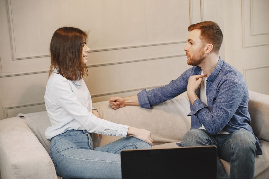 Homem e mulher em uma conversa séria em ambiente de consultório ou sala de atendimento, representando aconselhamento ou suporte emocional.