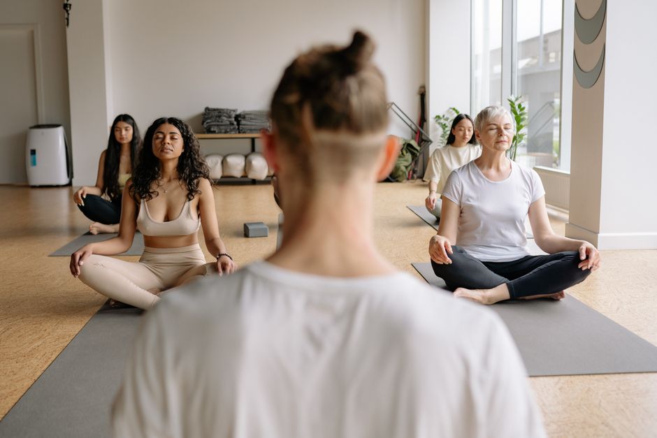 Mulheres praticando yoga em um ambiente tranquilo, focando no bem-estar e relaxamento.