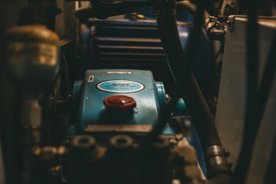 Imagem de um motor de máquina, enfatizando componentes mecânicos, utilizada para ilustrar manutenção ou funcionamento de equipamentos industriais.