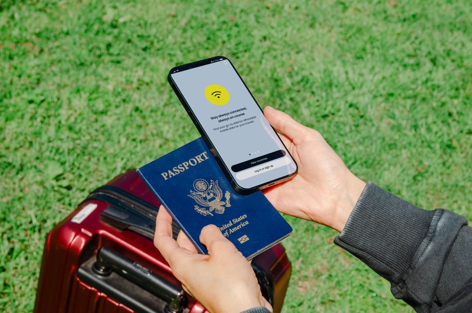 Pessoa com passaporte, mala e smartphone acessando Wi-Fi ao ar livre, simbolizando viagens internacionais e conectividade global.