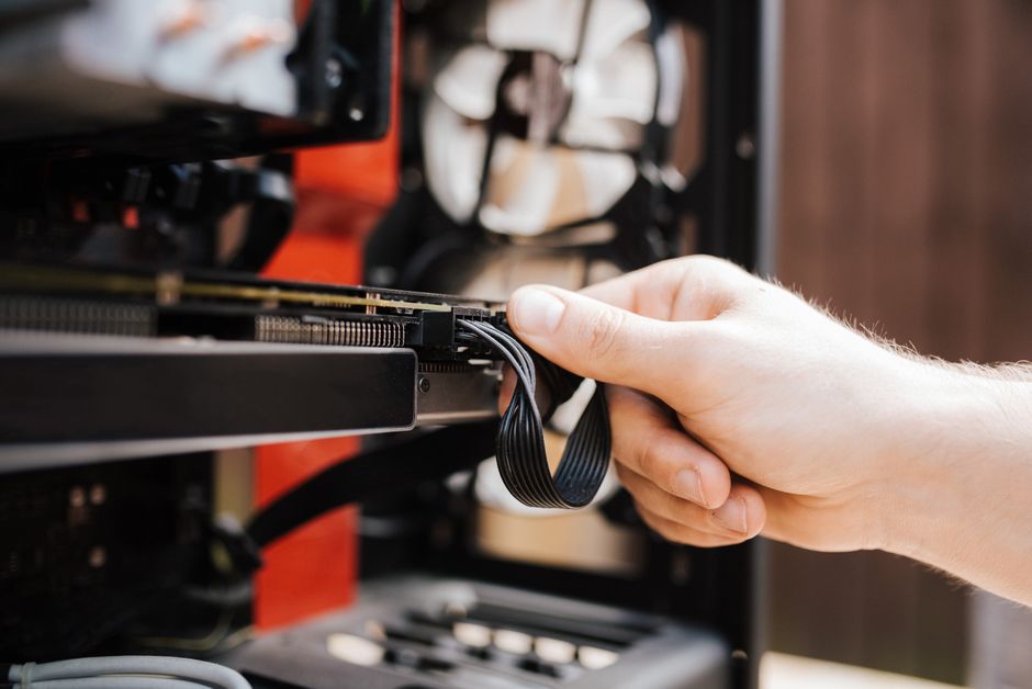 Pessoa realizando a instalação ou manutenção do hardware de um computador de alta performance, possivelmente para mineração, tecnologia ou componentes eletrônicos.