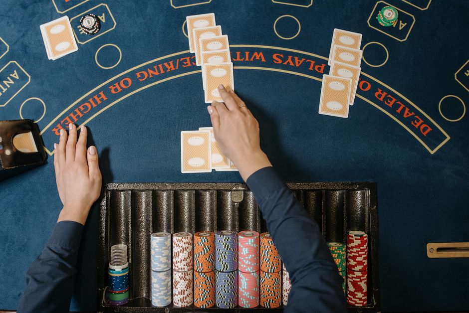 Jogo de pôquer sendo jogado em um ambiente de cassino, com fichas e cartas dispostas na mesa