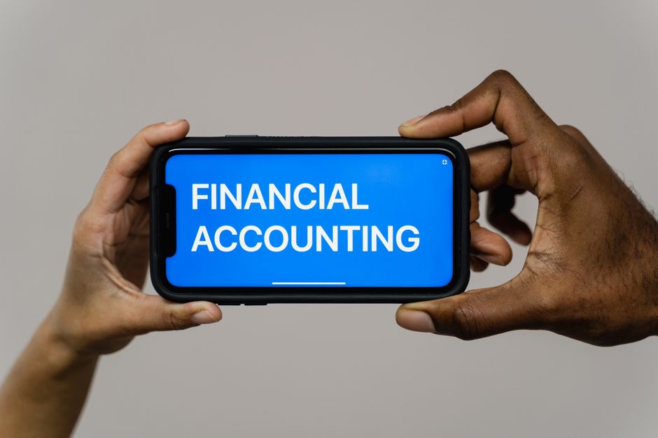 Imagem de uma pessoa segurando um smartphone com destaque para o tema contabilidade financeira, ideal para artigos sobre gestão financeira ou controle orçamentário.