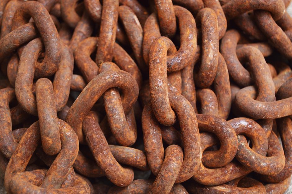 Imagem de correntes de ferro enferrujadas, simbolizando resistência, bloqueios ou obstáculos relacionados a temas de segurança ou dificuldade.