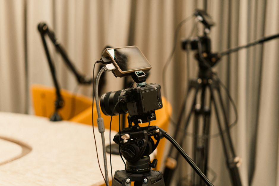 Equipamento de gravação de vídeo em um estúdio, com câmera, smartphone e tripé prontos para captura de conteúdo audiovisual.