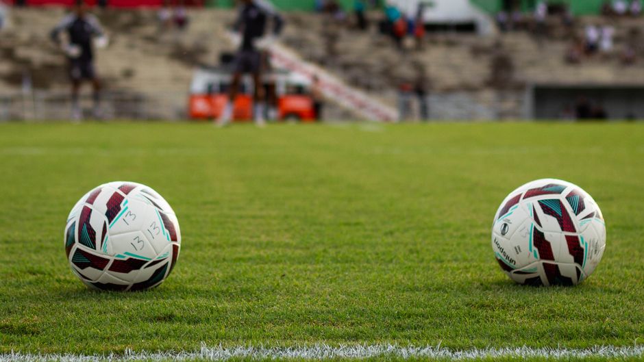 Imagem de um campo de futebol com dois gols de futebol, preparados para uma partida ou treino.