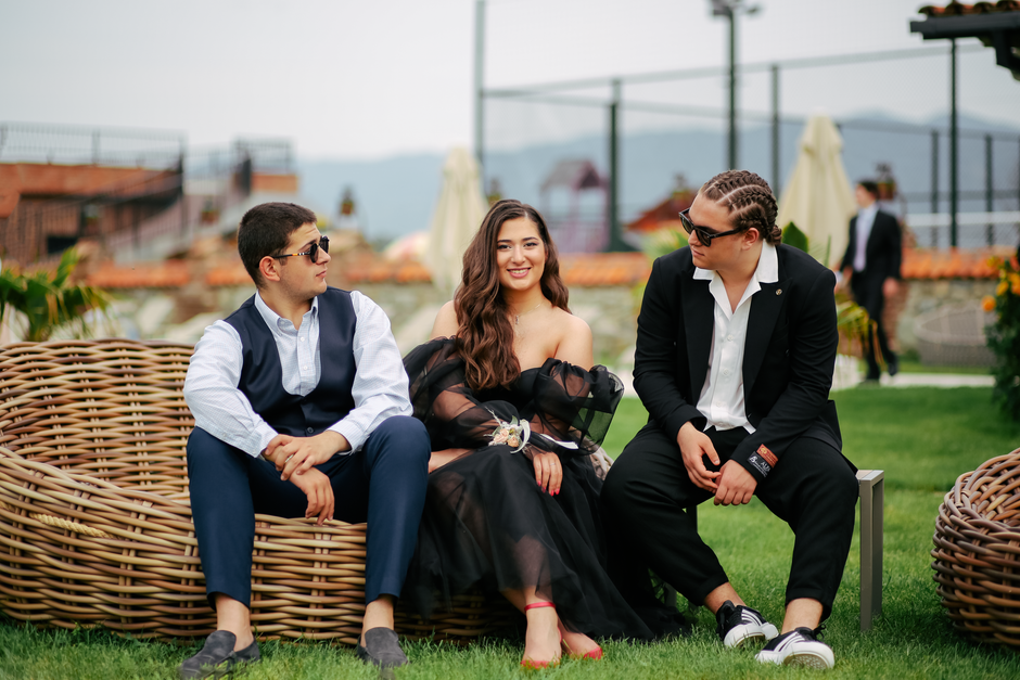 Grupo de jovens bem vestidos conversando e sorrindo ao ar livre, em um ambiente de lazer e confraternização.