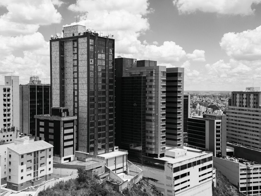 Imagem de um cenário urbano com arranha-céus de escritórios, simbolizando o ambiente corporativo e negócios na cidade.