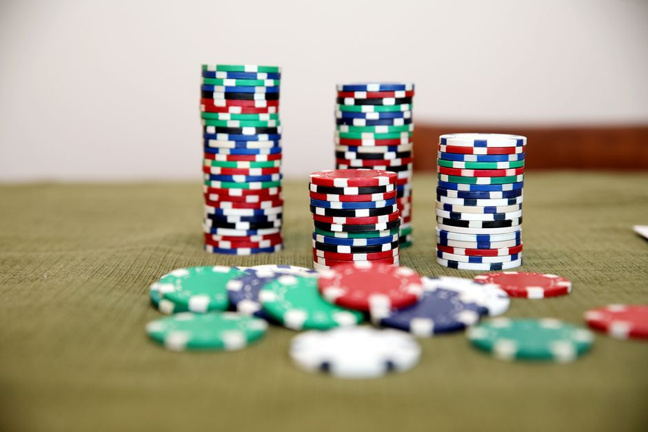 Imagem de pilhas de fichas de poker organizadas em diferentes alturas, simbolizando apostas e estratégias de jogo.