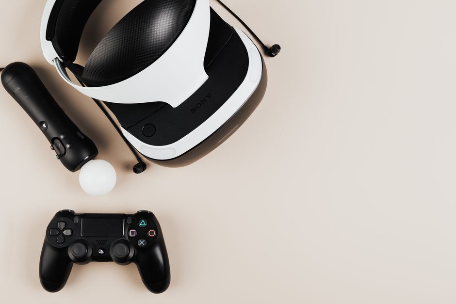 Imagem que mostra um conjunto de equipamentos de entretenimento e tecnologia, incluindo um óculos de realidade virtual, um controle de videogame, um sensor de movimento, e um headset, ideal para ilustrar artigos sobre jogos digitais ou inovação em tecnologia de lazer.