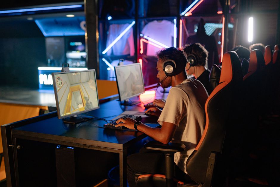 Jogadores de e-sports concentrados em uma partida em um ambiente de competição de videogame com iluminação vibrante.