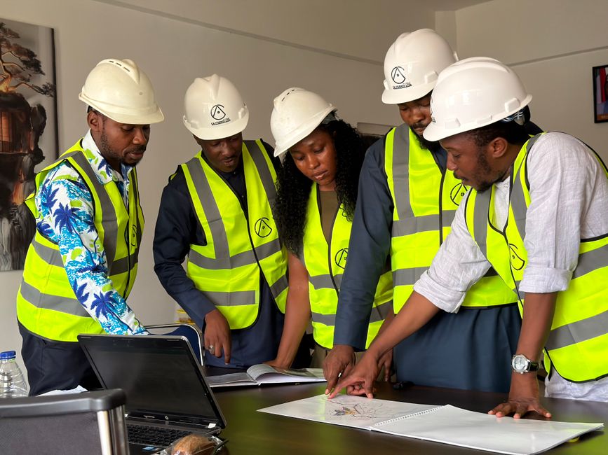 Grupo de profissionais de engenharia analisando projetos e planejando obras em reunião de trabalho.