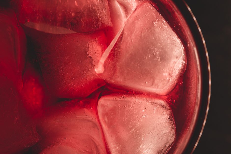 Imagem de uma bebida escura com gelo em um copo, transmitindo frescor e sabor intenso, ideal para artigos relacionados a bebidas e gastronomia.