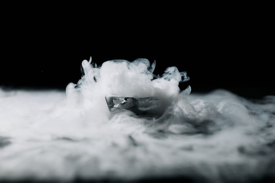 Imagem artística de um recipiente com fumaça ou vapor saindo, criando um efeito visual misterioso e dramático.
