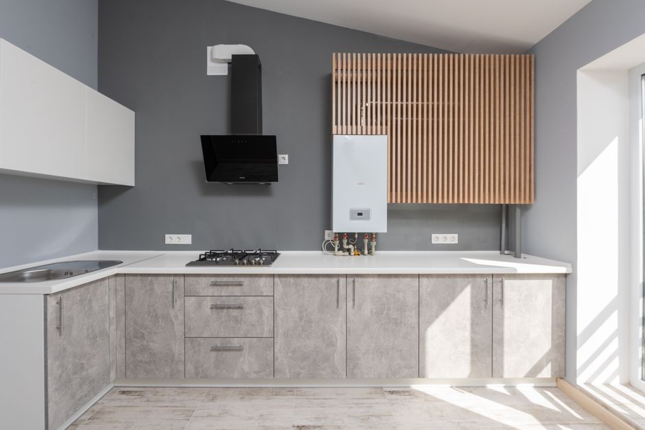 Imagem de uma cozinha moderna e minimalista com armários de concreto, fachada de painel de madeira e eletrodomésticos embutidos, ideal para ilustrar design de interiores e decoração de cozinhas contemporâneas.