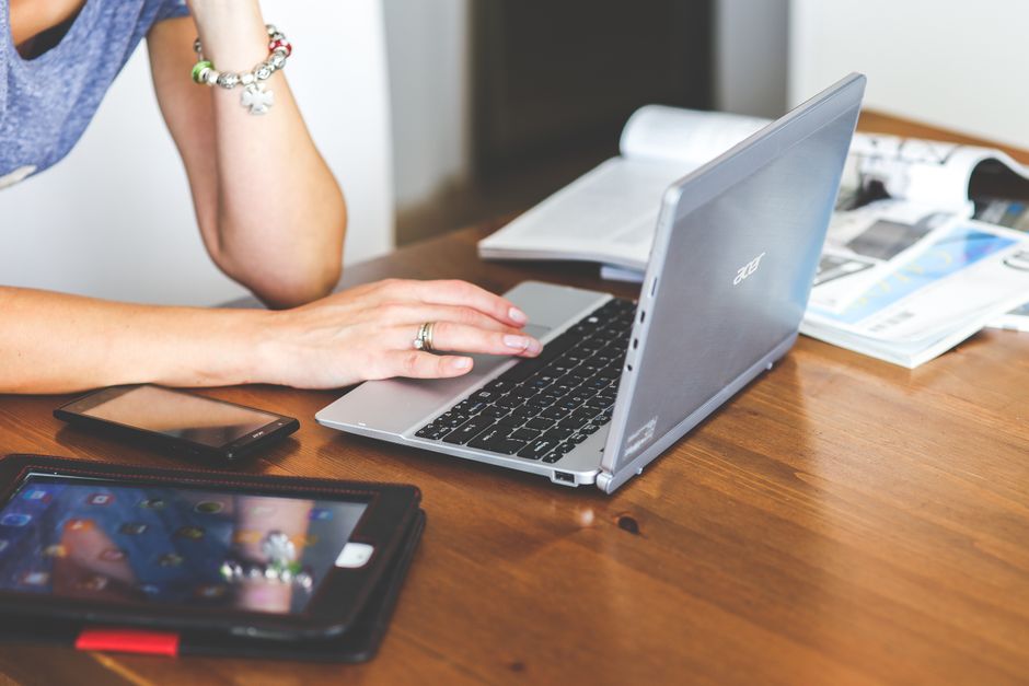 Pessoa trabalhando em um ambiente de escritório com laptop, celular e documentos, destacando o foco em produtividade e organização profissional.