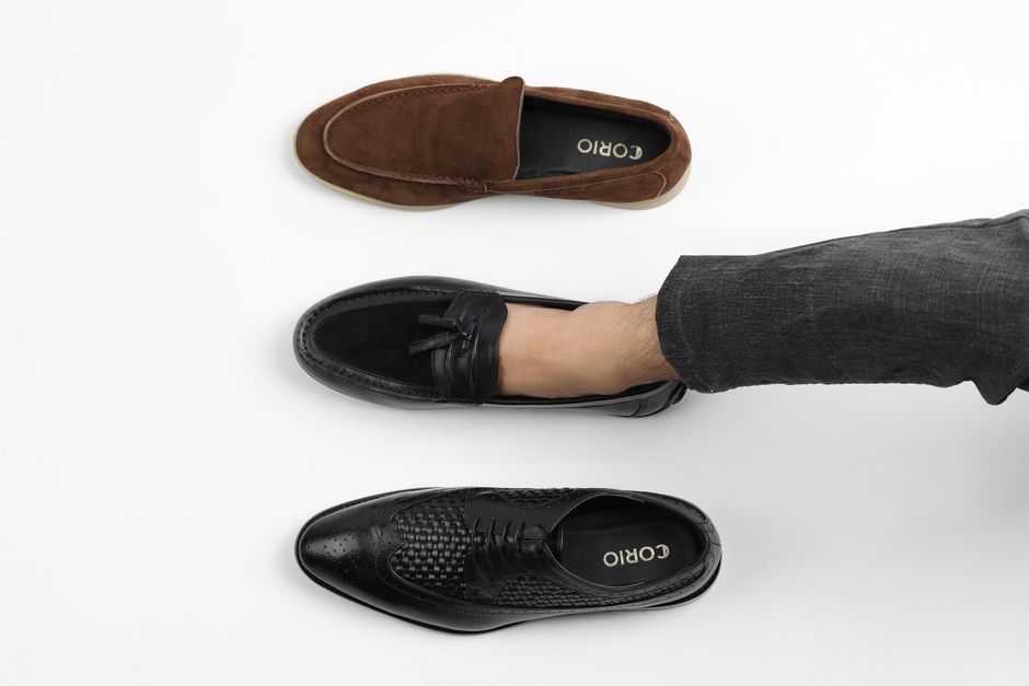 imagem de um pé vestindo uma sapatilha social, com dois outros sapatos ao lado, representando escolha de estilo ou dúvidas sobre look profissional