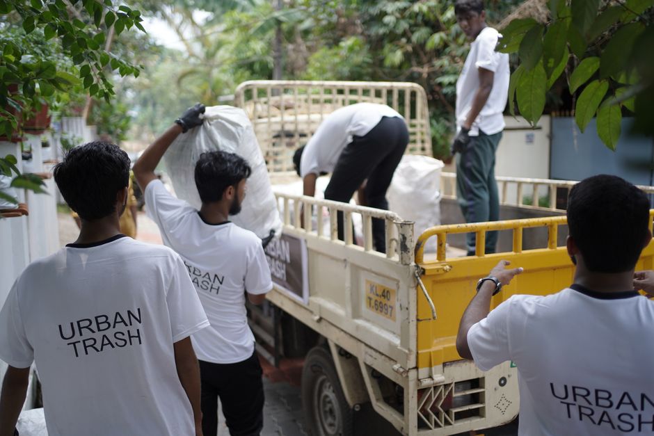 Grupo de jovens realizando coleta de lixo urbano em uma ação de conscientização ambiental ao ar livre.