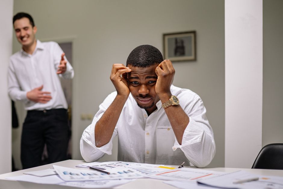 Homem passando por estresse financeiro enquanto trabalha, ilustrando dificuldades em gestão de finanças pessoais ou empresariais.