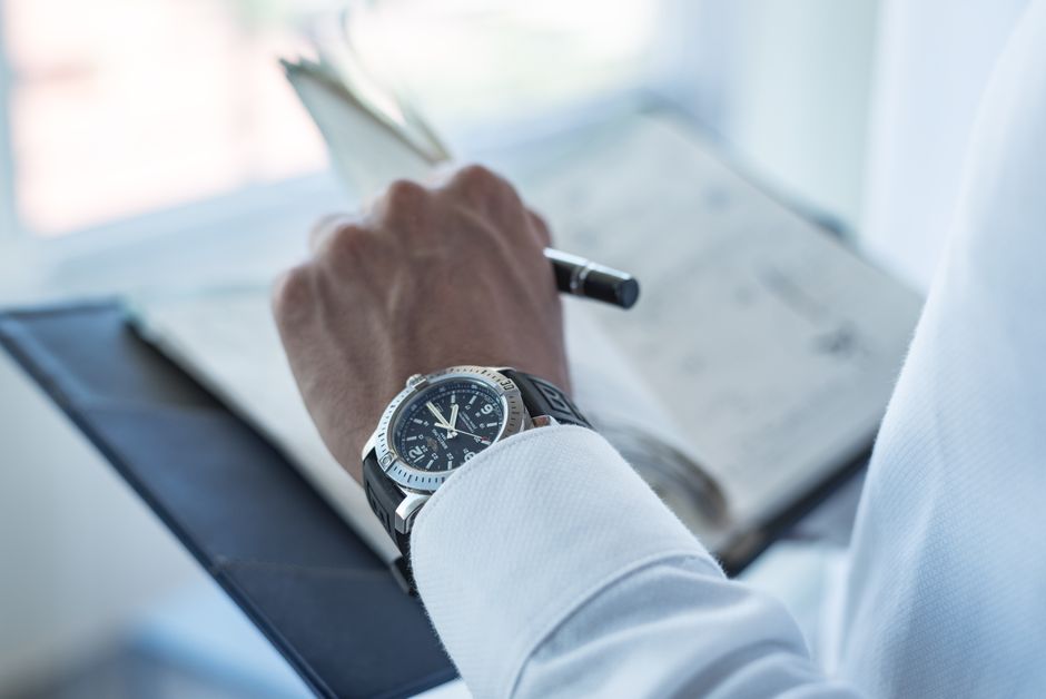 Homem anotando ideias ou planejando estratégias de negócios em um ambiente de escritório, com foco na gestão do tempo e planejamento empresarial.