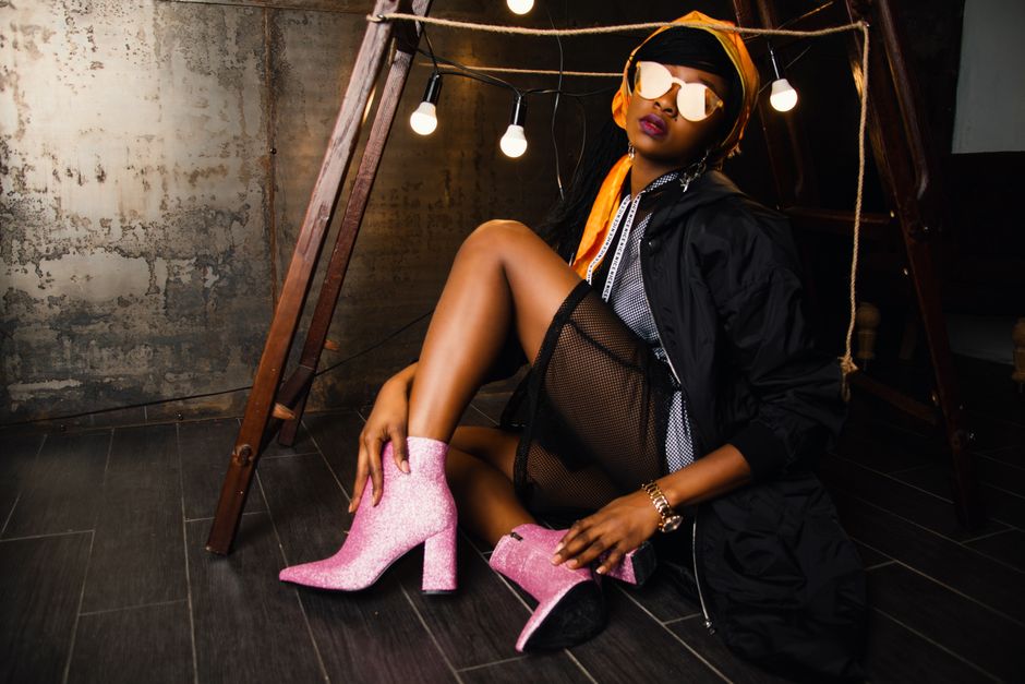 Mulher estilosa em um ambiente urbano com iluminação aconchegante, usando roupas modernas e acessórios marcantes, transmitindo uma vibe de moda contemporânea.