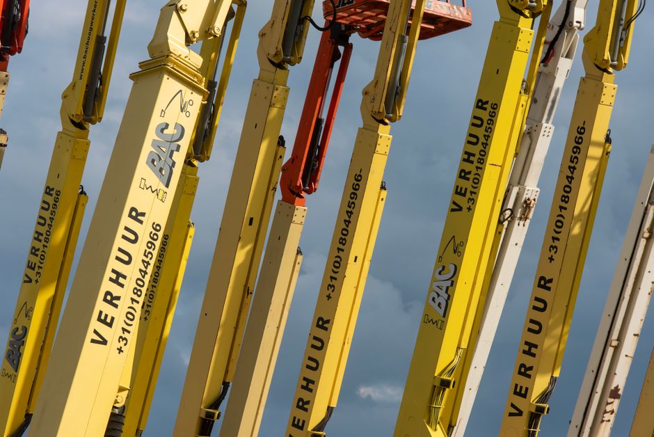Imagem de guindastes industriais usados na construção civil, destacando a força e a infraestrutura de obras de grande porte.