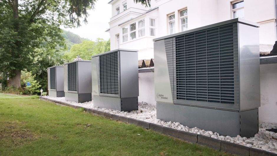 Imagem de ar-condicionados externos instalados ao lado de uma residência, destacando soluções de climatização residencial e eficiência energética.