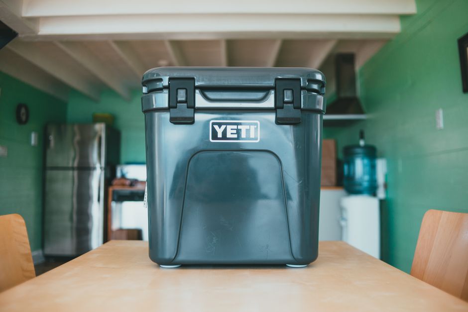Foto de uma caixa térmica YETI em uma cozinha, representando o tema de lazer, camping ou transporte de alimentos.