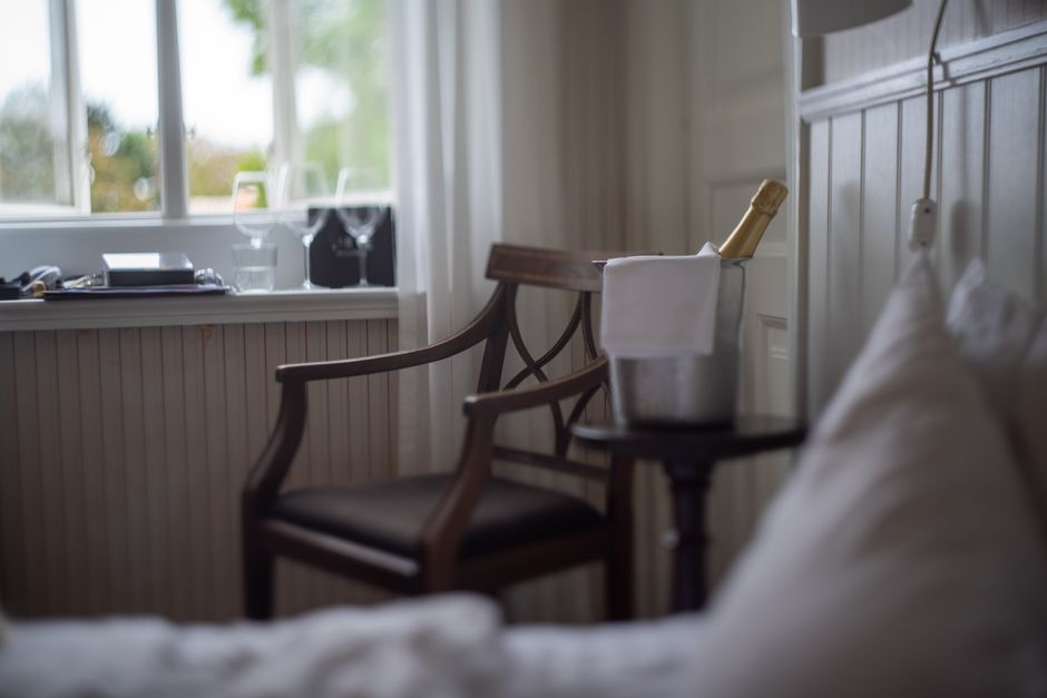 Imagem de um ambiente aconchegante com uma garrafa de champagne em balde de gelo, ideal para ilustrar momentos de celebração ou relaxamento em um blog de estilo de vida ou turismo.