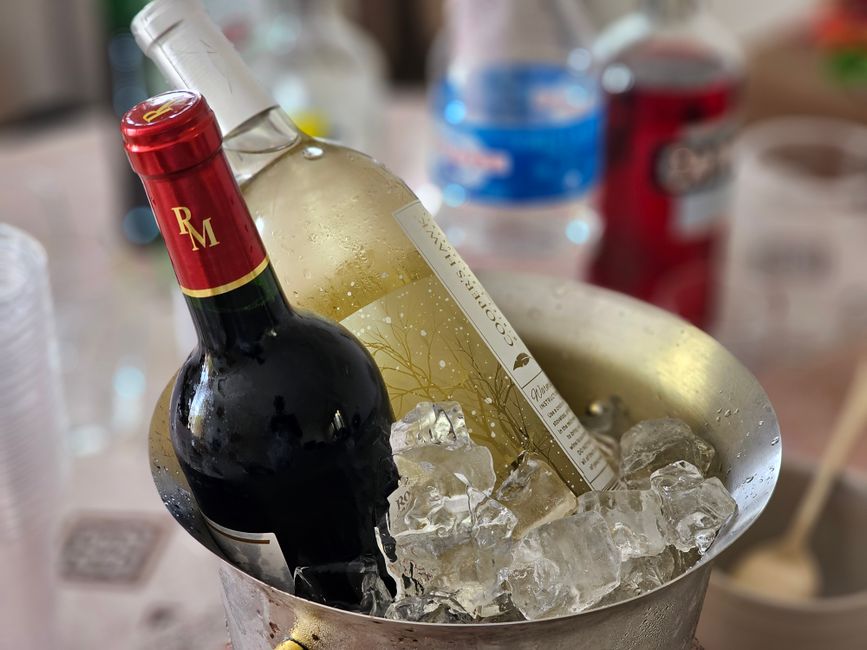 Vaso de bebida alcoólica gelada, com garrafa de vinho e gelo, pronto para consumo em uma ocasião social ou de celebração.