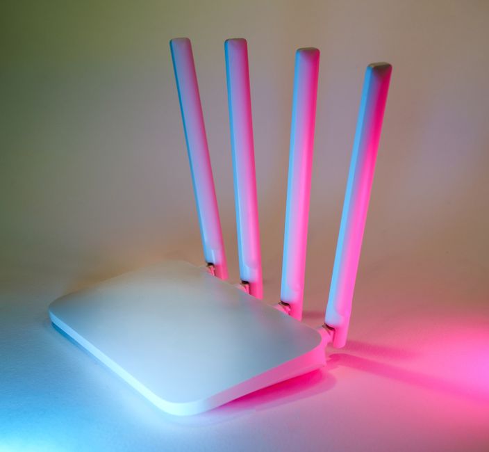 Roteador com luzes de cores vibrantes, simbolizando tecnologia e conexão de internet.