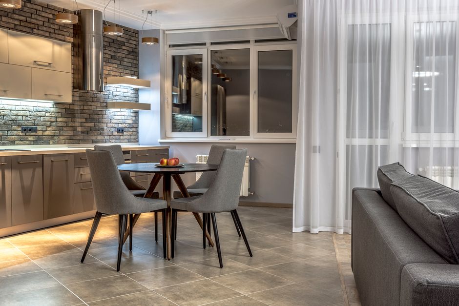 Imagem de uma sala de jantar moderna integrada à cozinha, com ambiente aconchegante e iluminação suave, ideal para artigos sobre design de interiores ou organização de espaços residenciais.