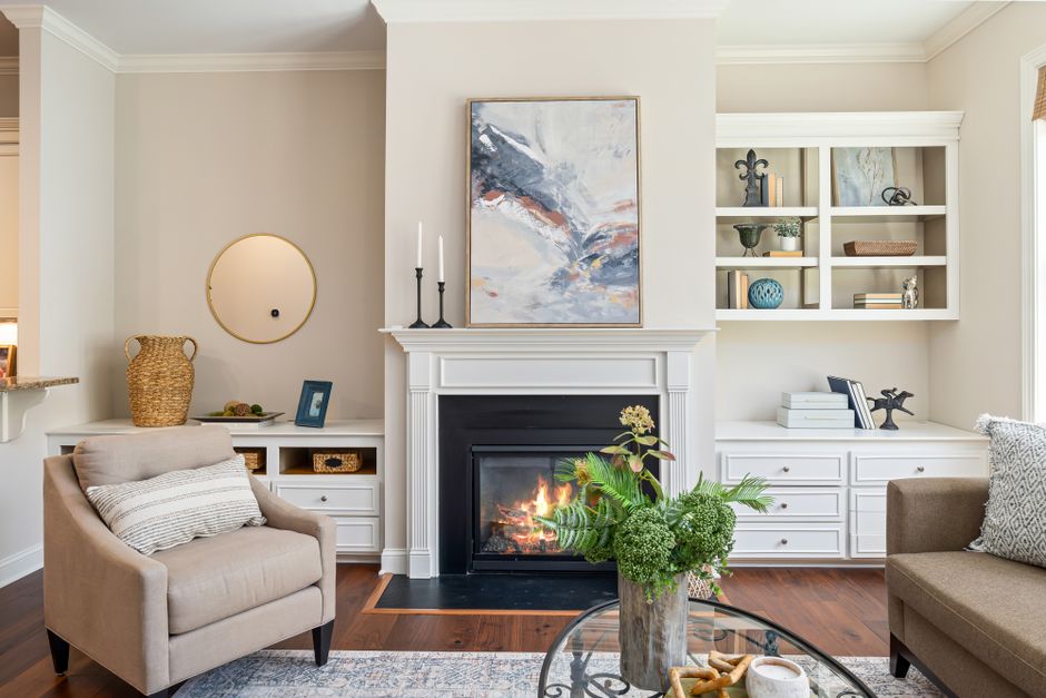 Sala de estar aconchegante com lareira, decorada com estilo clássico e detalhes elegantes, ideal para criar ambientes acolhedores. 