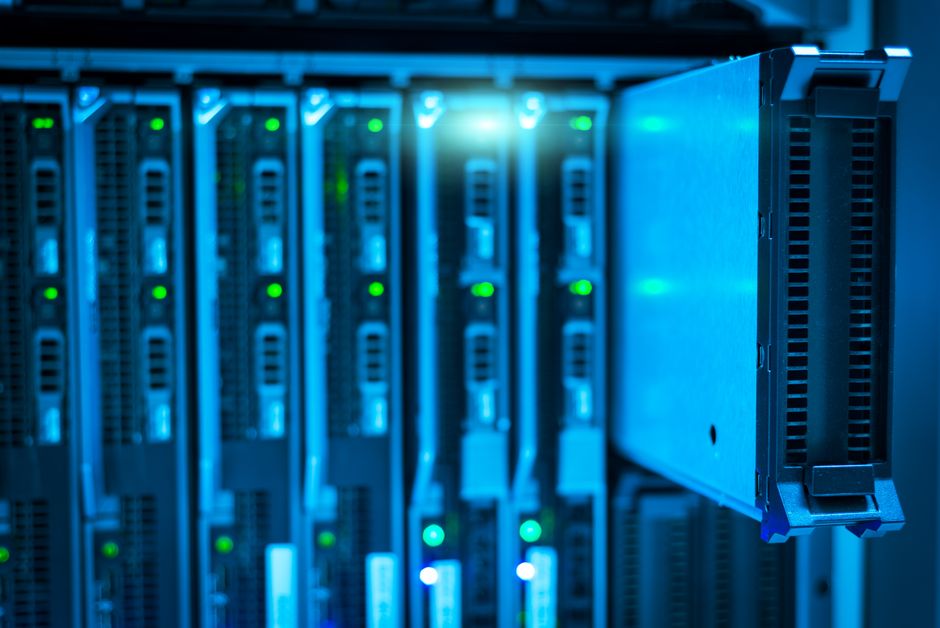 Imagem de um data center com servidores iluminados, representando tecnologia e infraestrutura de TI.