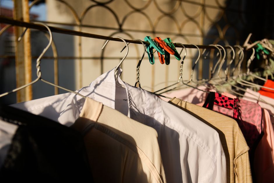 Roupas penduradas em varal ao ar livre, capturando um momento de convivência e cotidiano com iluminação natural.