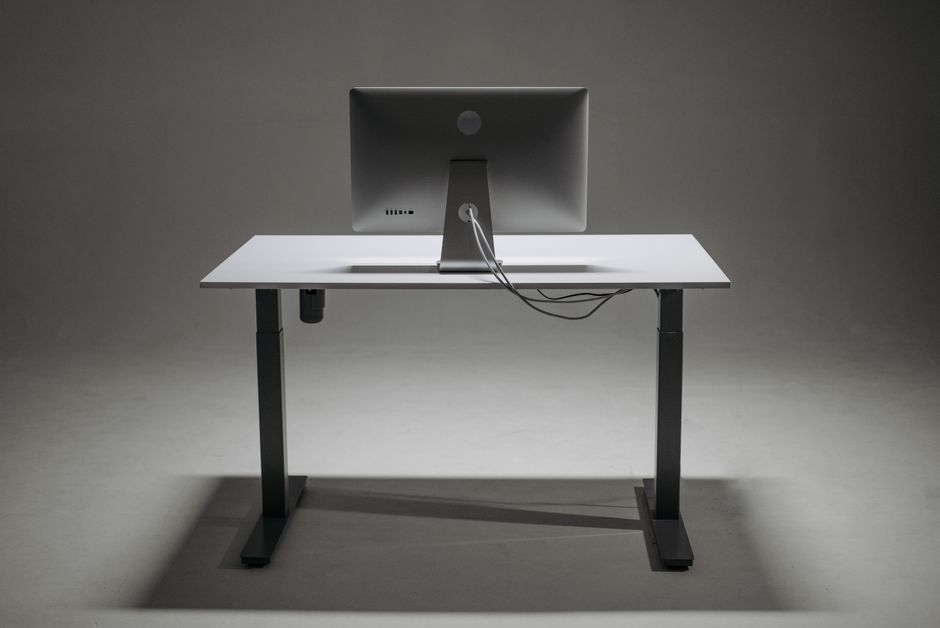 Imagem de uma mesa de escritório com um monitor de computador vazio, representando trabalho remoto ou ambiente de trabalho digital.