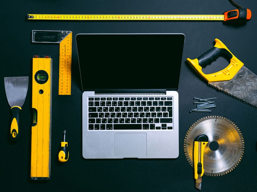 Imagem de ferramentas manuais ao redor de um laptop, simbolizando trabalho de marcenaria ou manutenção industrial.