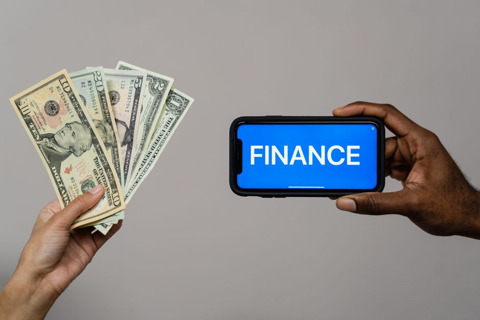 Imagem que ilustra a relação entre dinheiro e gestão financeira, simbolizando investimento ou controle financeiro através do uso de dispositivos digitais.