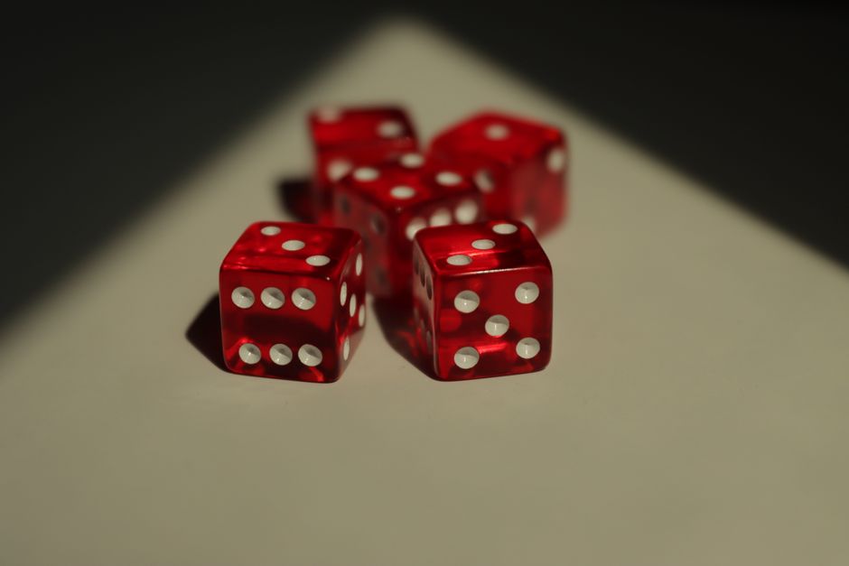 Imagem de dados vermelhos de cassino sobre uma superfície clara, representando o tema de jogos de azar e sorte.