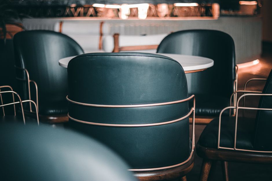 Imagem de uma mesa de reunião em um ambiente corporativo com cadeiras de design moderno, ideal para discussões de negócios ou planejamento estratégicos.