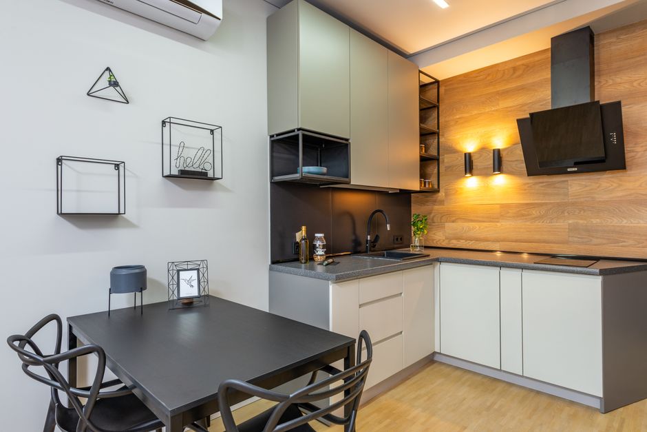 Imagem de uma cozinha moderna integrada ao ambiente de trabalho, com design minimalista e iluminação acolhedora ao fundo.