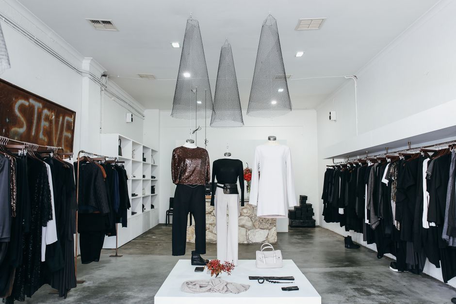 Interior de boutique de moda feminina com manequins exibindo roupas sofisticadas, destacando o ambiente de vendas e estilo de vestuário.